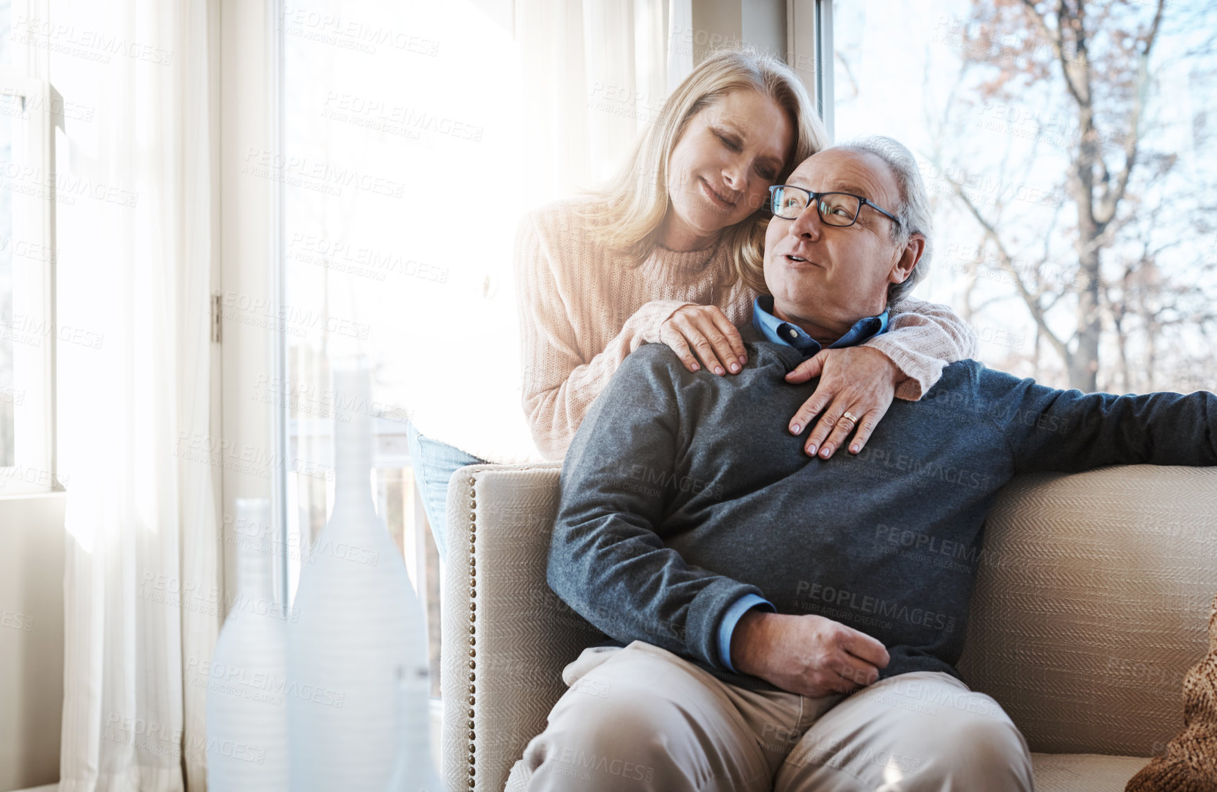 Buy stock photo Shot of a loving mature couple relaxing together at home