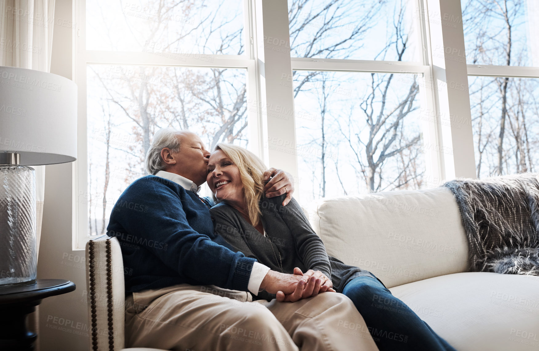 Buy stock photo Shot of a loving mature couple relaxing together at home