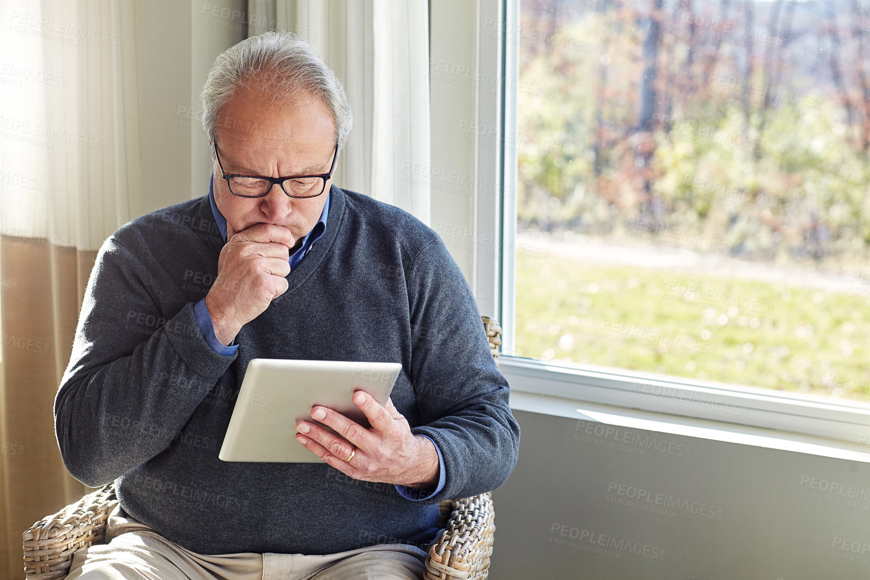 Buy stock photo Cropped shot of a senior man using a tablet at home