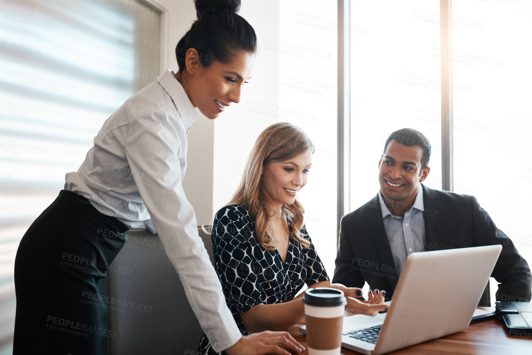 Buy stock photo Shot of a group of businesspeople working together on a laptop in an office