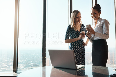 Buy stock photo Shot of a businesswoman showing her colleague something on her cellphone in an office