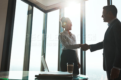 Buy stock photo Shot of two businesspeople shaking hands in an office