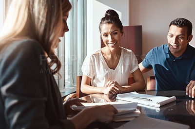 Buy stock photo Shot of a young couple meeting with a financial planner in a modern office