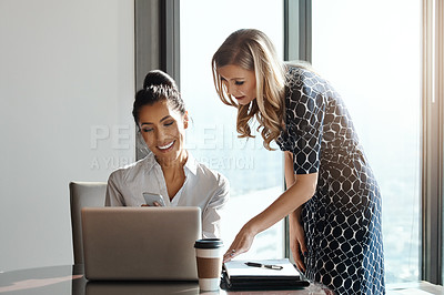 Buy stock photo Cropped shot of two attractive young businesswomen working in a modern office