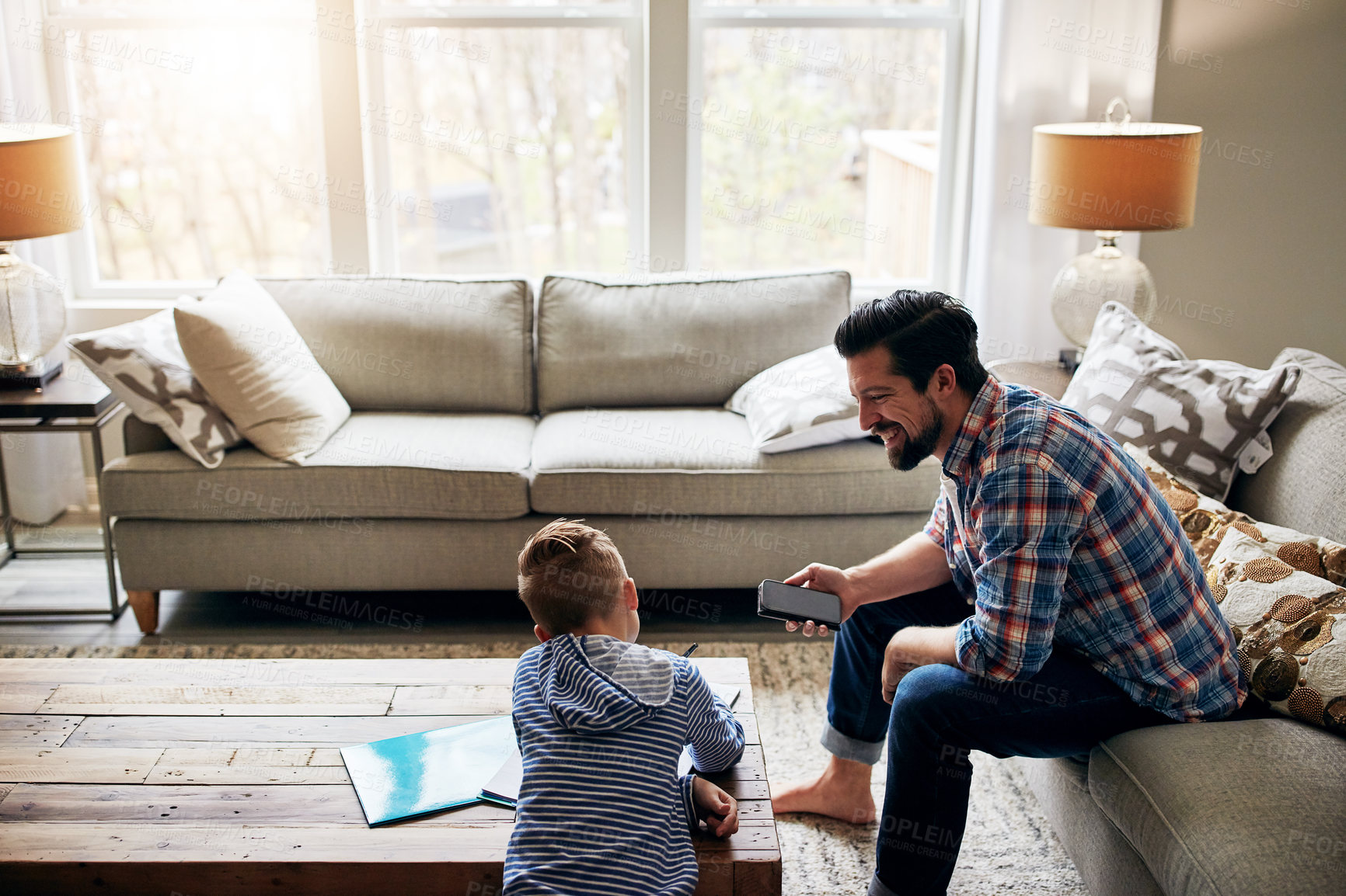 Buy stock photo Shot of a father helping his little son with his homework