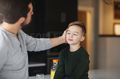 Buy stock photo Cropped shot of a handsome young man talking to his son while standing in the kitchen