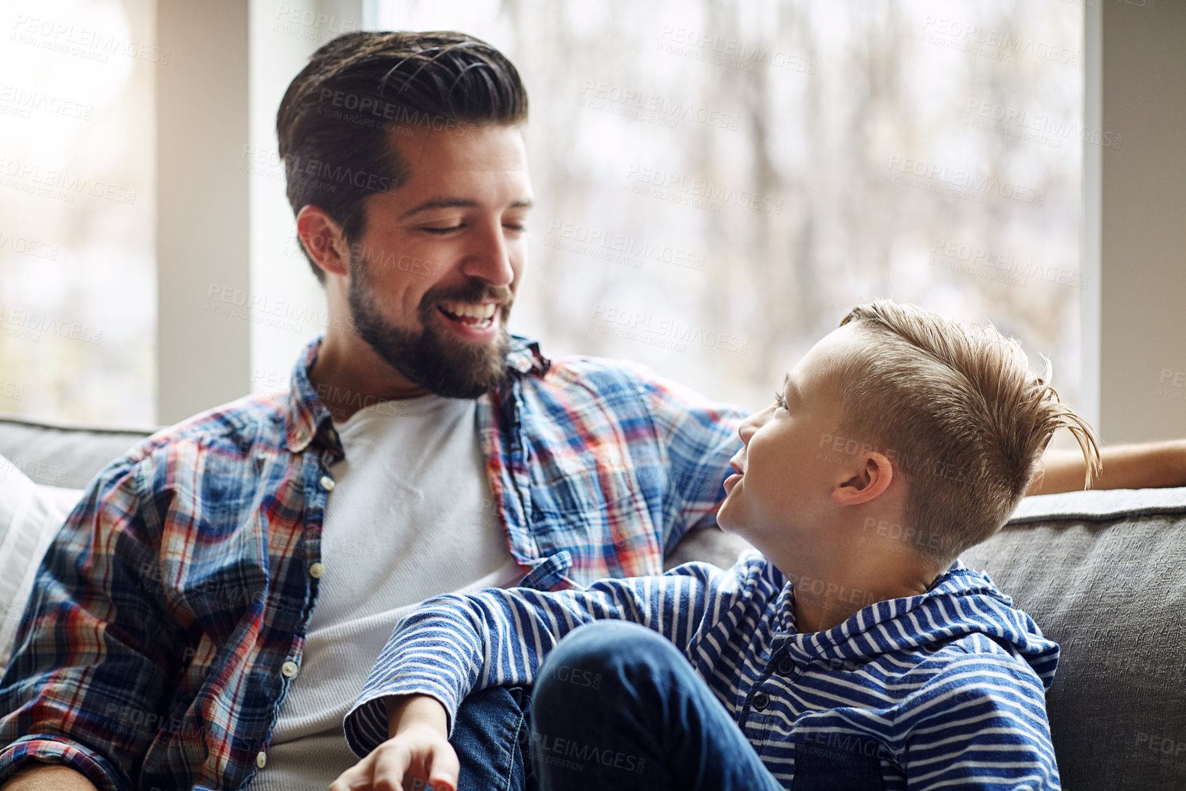 Buy stock photo Shot of a father and his little son bonding together at home