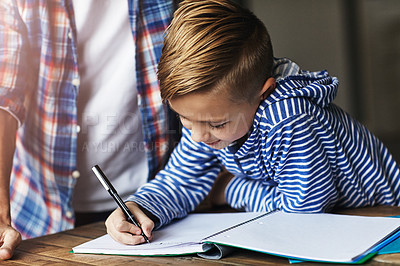 Buy stock photo Shot of a little boy doing his homework with his father at home