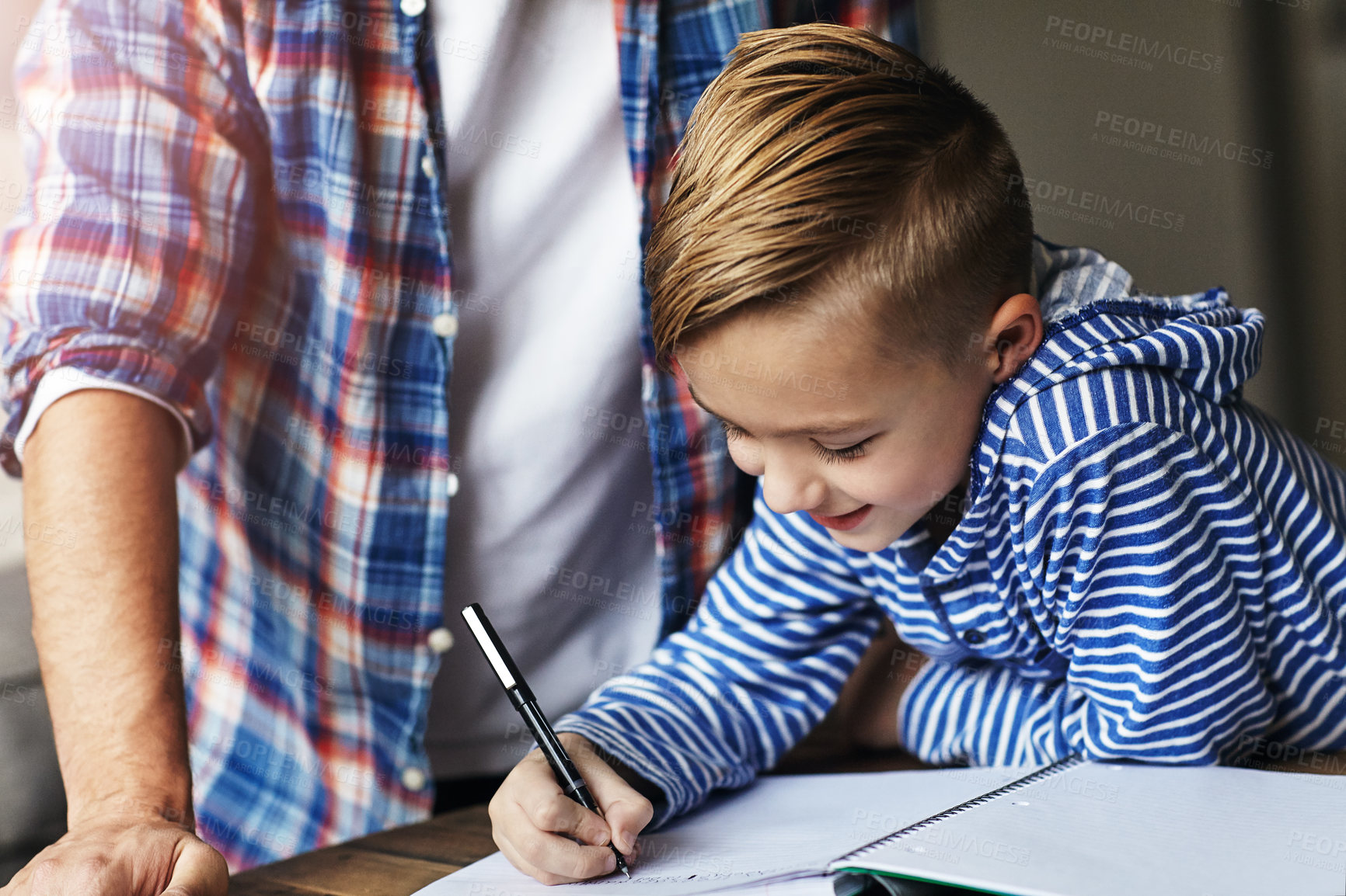 Buy stock photo Shot of a little boy doing his homework with his father at home