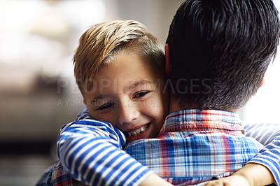 Buy stock photo Shot of an adorable little boy hugging his father at home