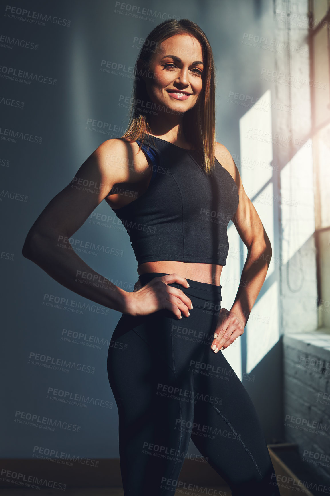 Buy stock photo Cropped portrait of an attractive young sportswoman standing with her hands on her hips
