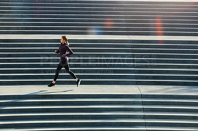 Buy stock photo Full length shot of an attractive young sportswoman running up and down stairs outside