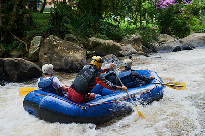 Buy stock photo Shot of a group of young male friends white water rafting