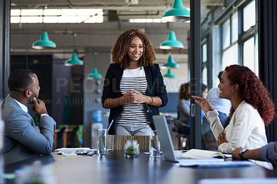 Buy stock photo Cropped shot of an attractive young businesswoman addressing her colleagues in the boardroom