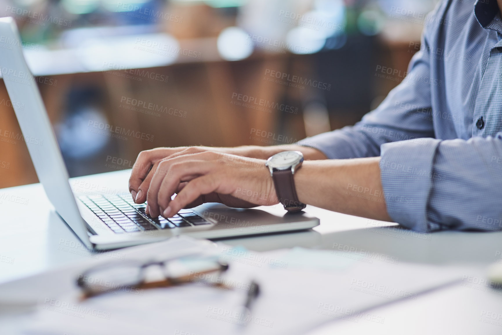 Buy stock photo Closeup shot of an unrecognizable businessman working on a laptop in an office
