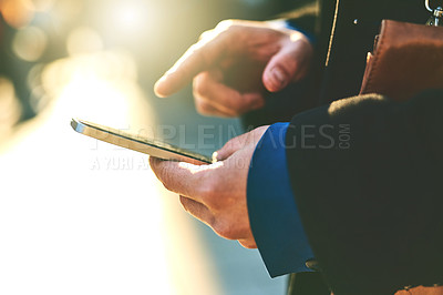 Buy stock photo Shot of an unrecognizable man texting on his phone while waiting for a taxi to get to work in the morning
