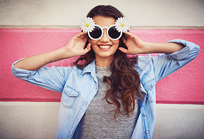 Buy stock photo Cropped shot of a beautiful young woman wearing novelty sunglasses and posing against a wall outside