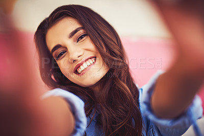 Buy stock photo Cropped shot of a beautiful young woman taking a selfie against a wall outside