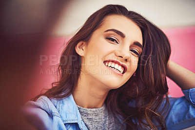 Buy stock photo Cropped shot of a beautiful young woman taking a selfie against a wall outside