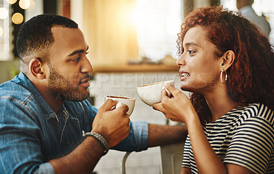Buy stock photo Cropped shot of a young couple talking while sitting in a coffee shop