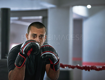 Buy stock photo Cropped portrait of a young male athlete training inside a boxing ring