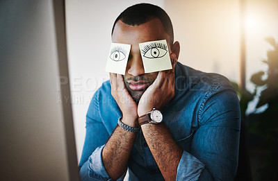 Buy stock photo Shot of a tired young businessman working late in an office with sticky notes covering his eyes