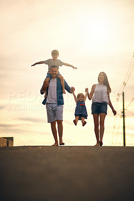 Buy stock photo Shot of a young family taking a walk down the road outside