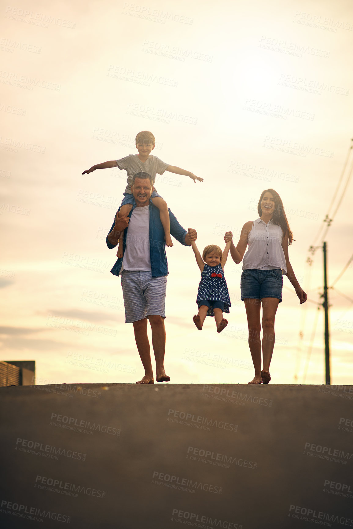 Buy stock photo Shot of a young family taking a walk down the road outside