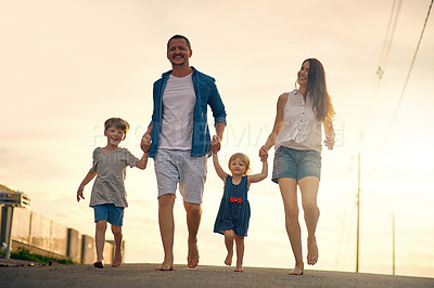 Buy stock photo Shot of a young family taking a walk down the road outside