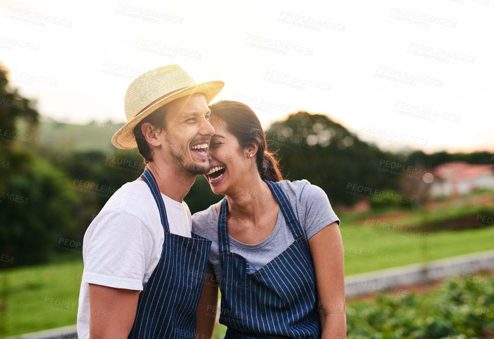 Buy stock photo Cropped shot of an affectionate young couple laughing while working on their privately owned farm