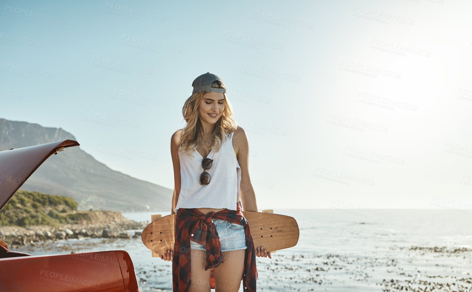 Buy stock photo Cropped shot of an attractive young woman holding a skateboard while on a road trip