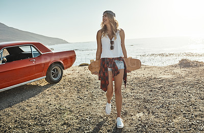 Buy stock photo Shot of an attractive young woman holding a skateboard while on a road trip