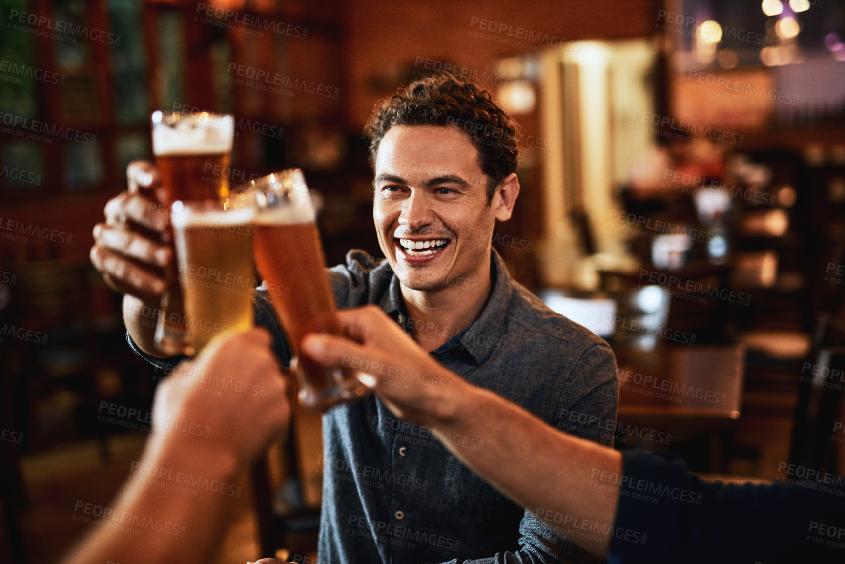Buy stock photo Beers, cheers and man drinking with friends at social event in a restaurant with happiness. Alcohol, glasses and toast at a pub at happy hour with smile and conversation with drinks and celebration 