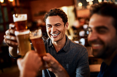 Buy stock photo Shot of a group of young friends seated at a table together while enjoying a beer and celebrating with a celebratory toast inside a bar