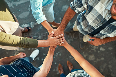 Buy stock photo High angle shot of an unrecognizable group of work colleagues forming a huddle with their hands while standing in the office at work