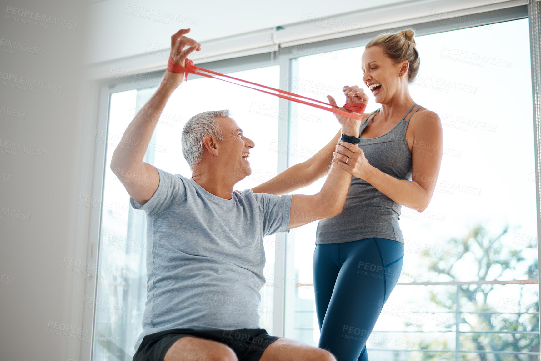 Buy stock photo Cropped shot of an attractive mature woman helping her husband with his workout at home