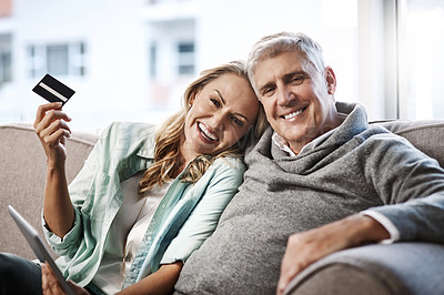 Buy stock photo Portrait of a mature couple using a digital tablet and credit card to do online shopping at home