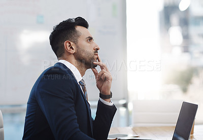 Buy stock photo Shot of a young businessman looking thoughtful in an office