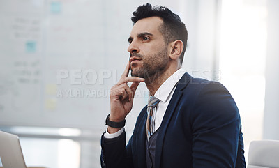 Buy stock photo Shot of a young businessman looking thoughtful in an office