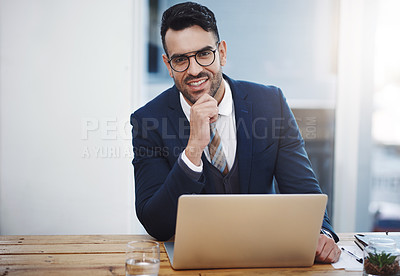 Buy stock photo Portrait of a young businessman working on a laptop in an office