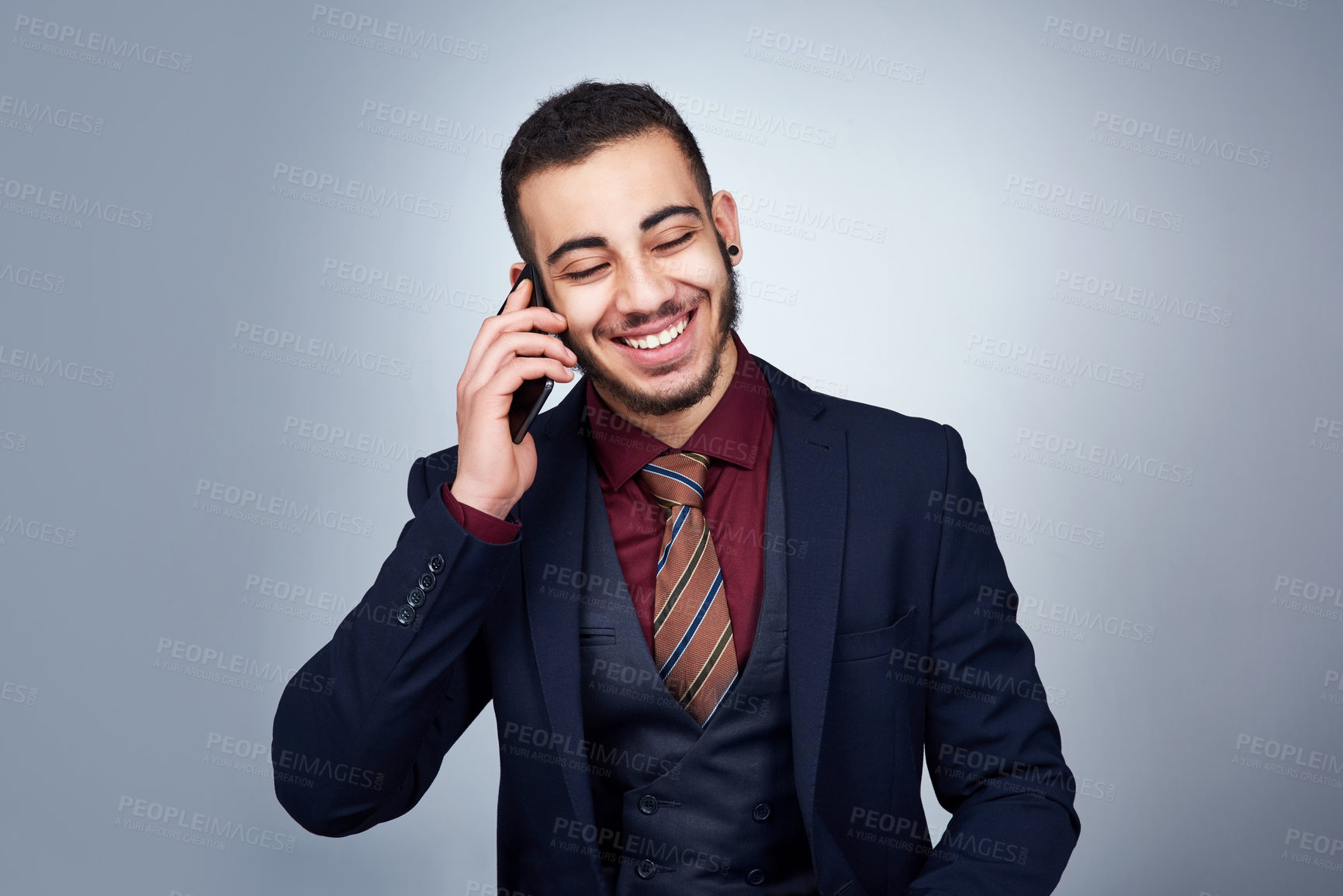 Buy stock photo Studio shot of a handsome young businessman on a call against a grey background