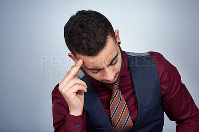 Buy stock photo Studio shot of a handsome young businessman experiencing a headache against a grey background