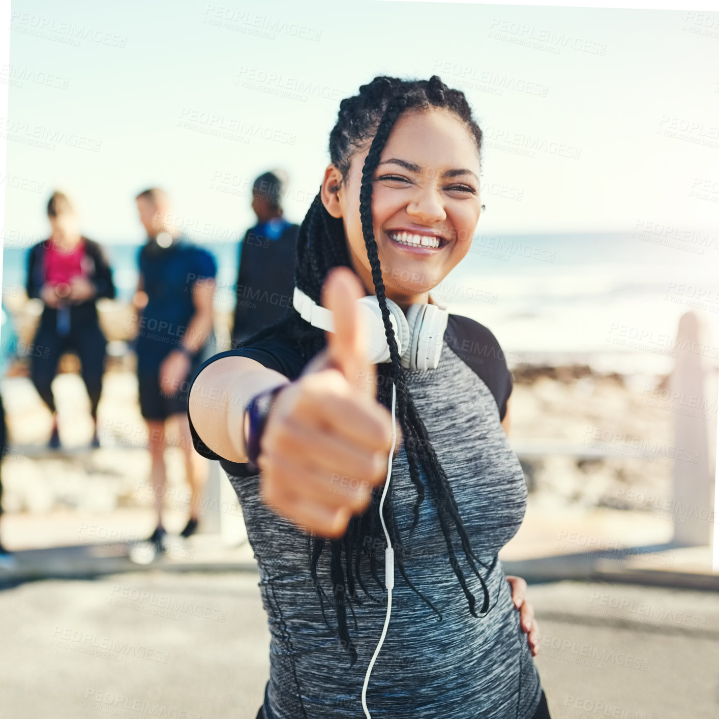 Buy stock photo Portrait of a sporty young woman showing thumbs up while exercising outdoors