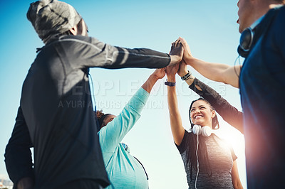 Buy stock photo Low angle shot of a group of sporty young people high fiving each other