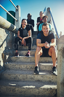 Buy stock photo Portrait of a group of sporty young people taking a break while exercising outdoors