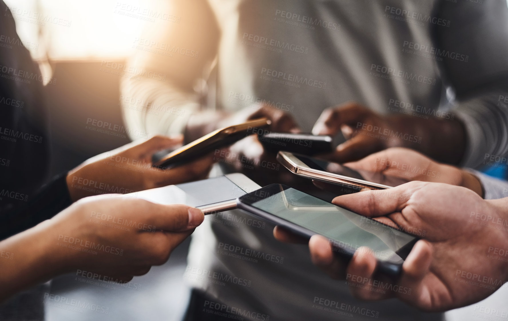 Buy stock photo Shot of a group of unrecognizable people using their mobile phones together in the gym