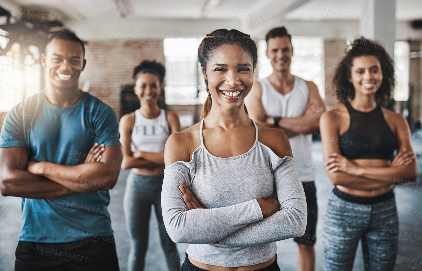 Buy stock photo Portrait of a group of confident young people working out together in a gym