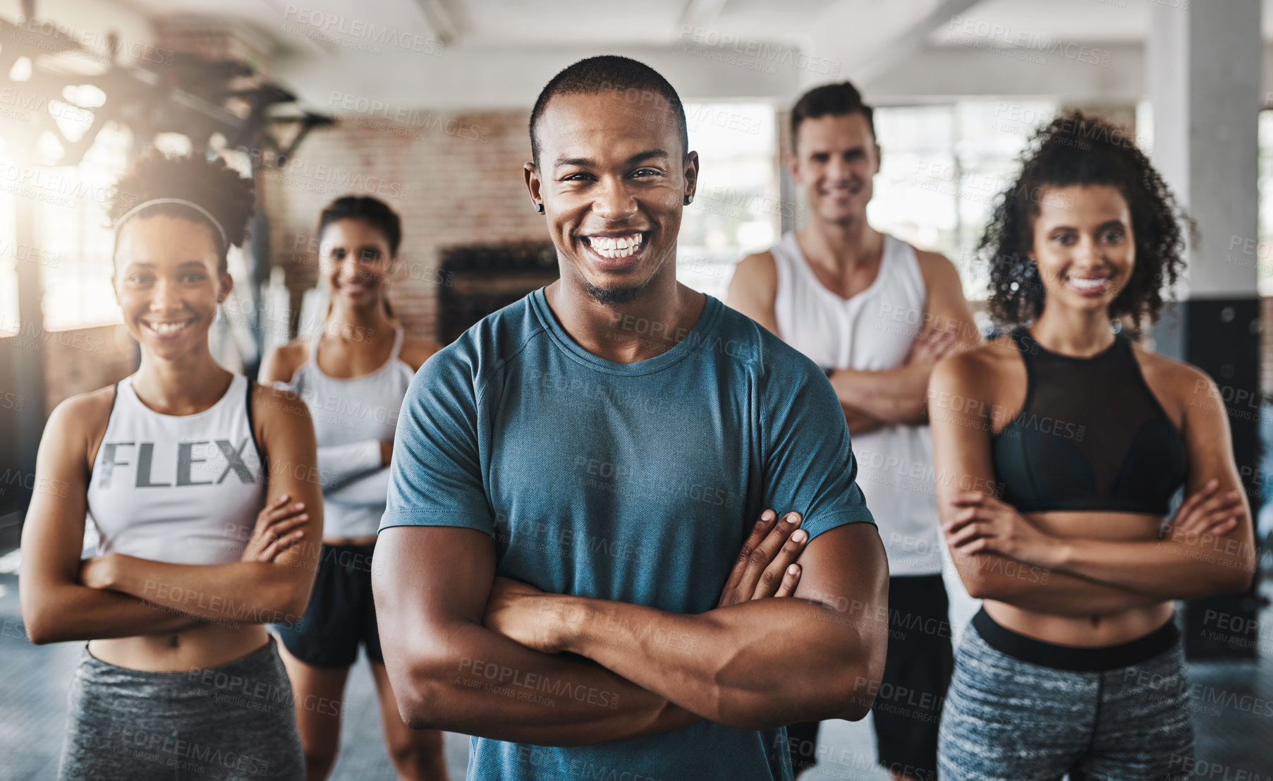Buy stock photo Portrait of a group of confident young people working out together in a gym