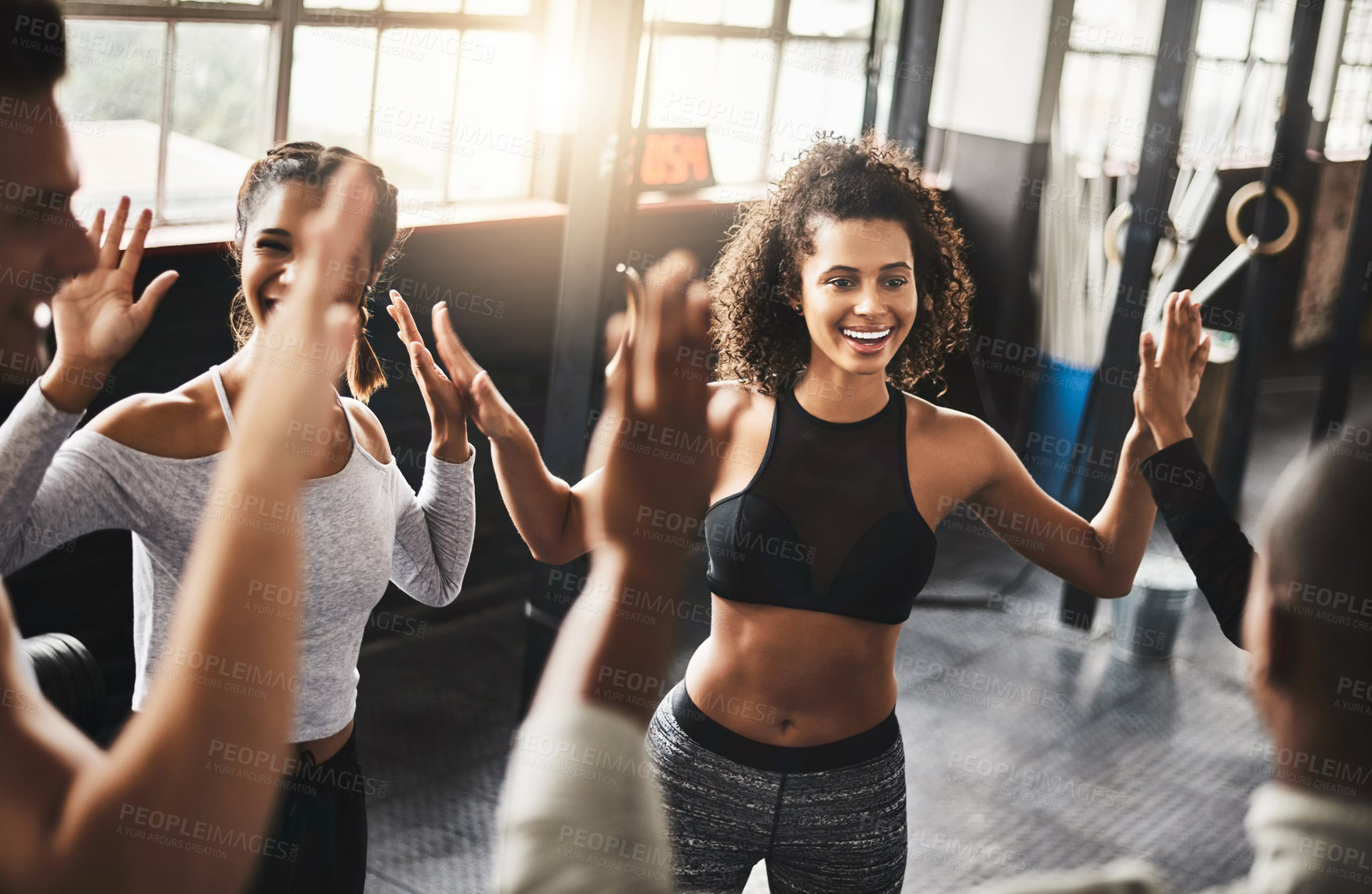 Buy stock photo Shot of a group of young people working out together in a gym