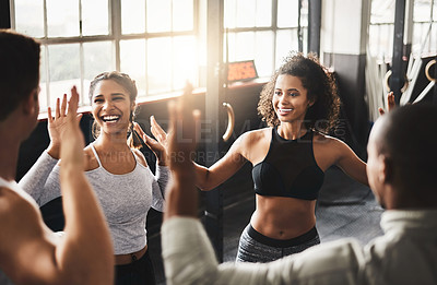 Buy stock photo Shot of a group of young people working out together in a gym